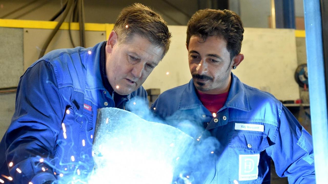 Ein syrischer Flüchtling arbeitet mit seinem Ausbilder in einem Metallbetrieb in Schleswig-Holstein Ein syrischer Flüchtling arbeitet mit seinem Ausbilder in einem Metallbetrieb in Schleswig-Holstein