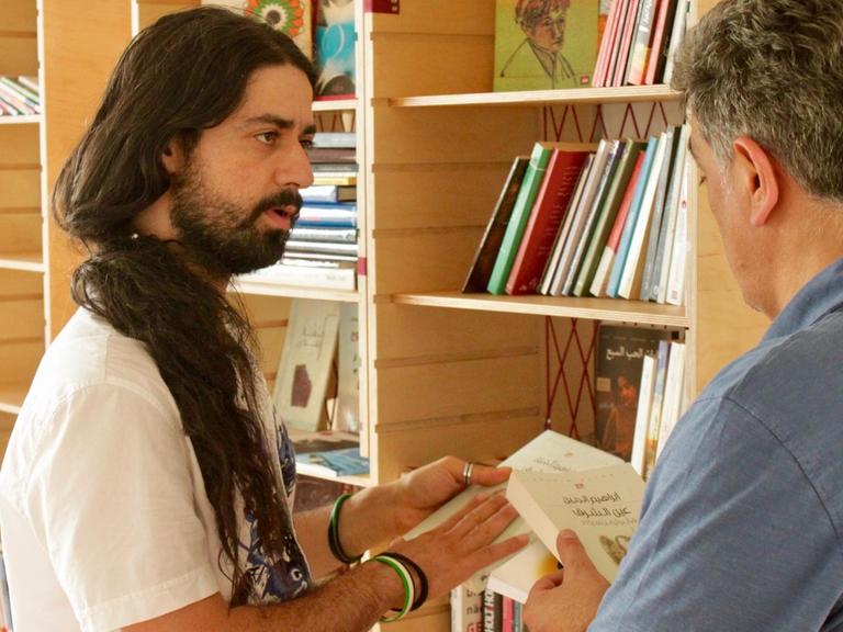 Wirbt für arabische Literatur: Muhannad Qaiconie (links) in der Bibliothek Baynatna.