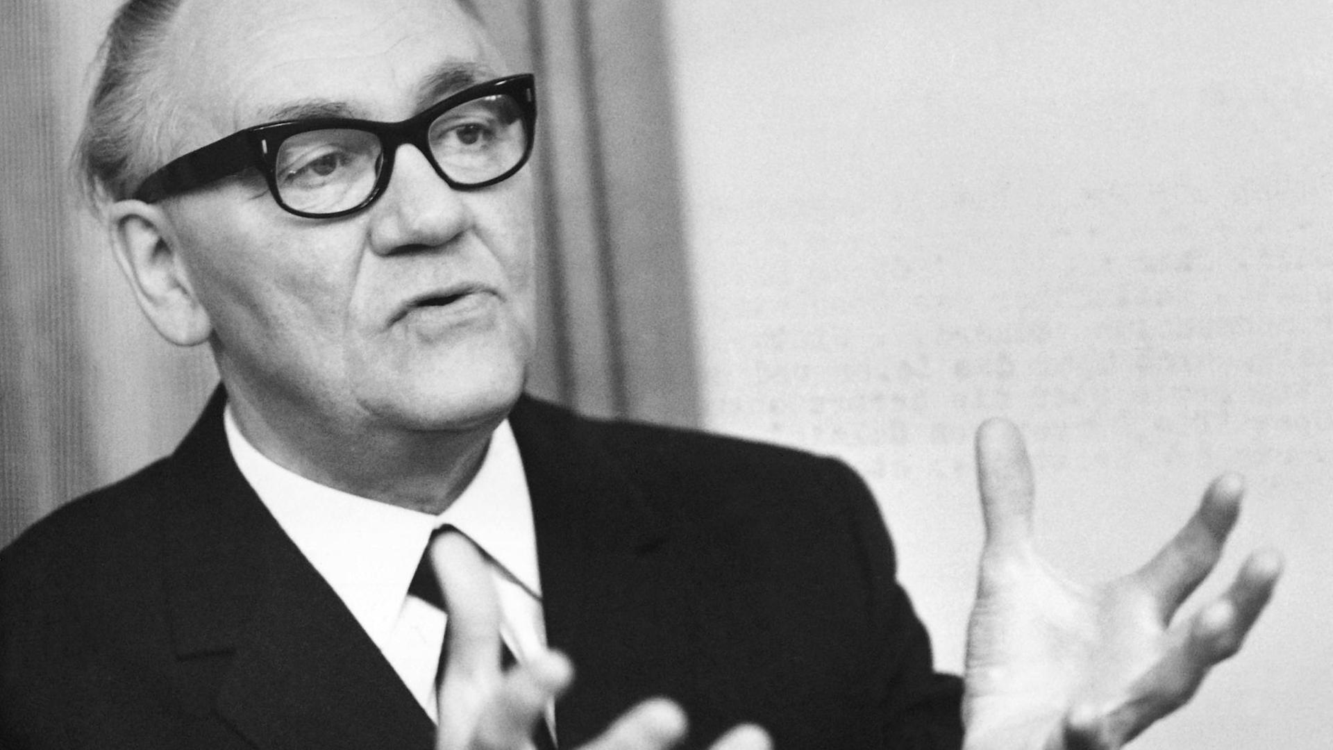 Porträt des Komponisten, der beide Hände im Gespräch Richtung Schulter erhoben hat. Porträt des Komponisten, der beide Hände im Gespräch Richtung Schulter erhoben hat.