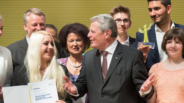 Bundespräsident Joachim Gauck mit Preisträgern bei der "Starke-Schule"-Preisverleihung auf eine Bühne.