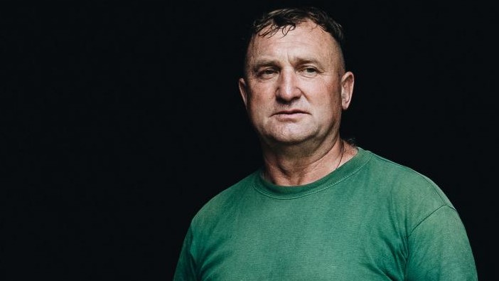 Alexej posiert vor schwarzem Hintergrund in grünem Shirt und Arbeitshose. Alexej posiert vor schwarzem Hintergrund in grünem Shirt und Arbeitshose.