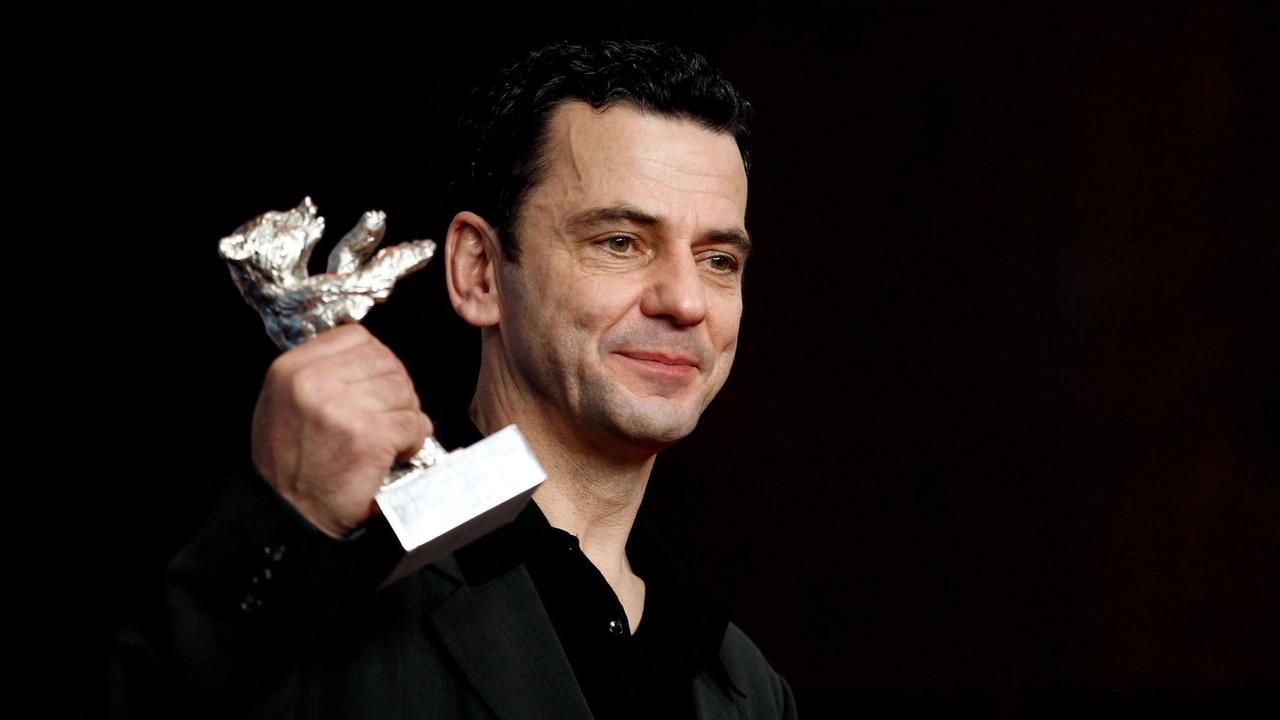 Der Regisseur Christian Petzold hält den silbernen Bären hoch, den er 2012 für den Film "Barbara" auf der Berlinale gewonnen hat.