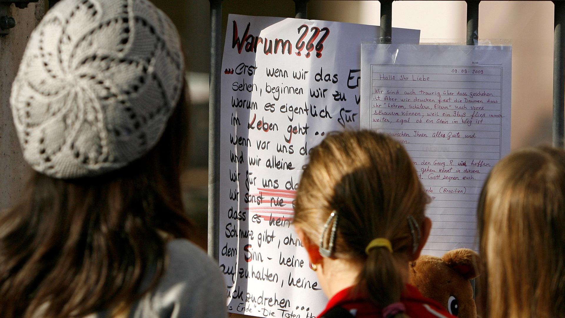 Jugendliche betrachten an einem Schultor einen Zettel mit dem Titel "Warum???" Jugendliche betrachten an einem Schultor einen Zettel mit dem Titel "Warum???"