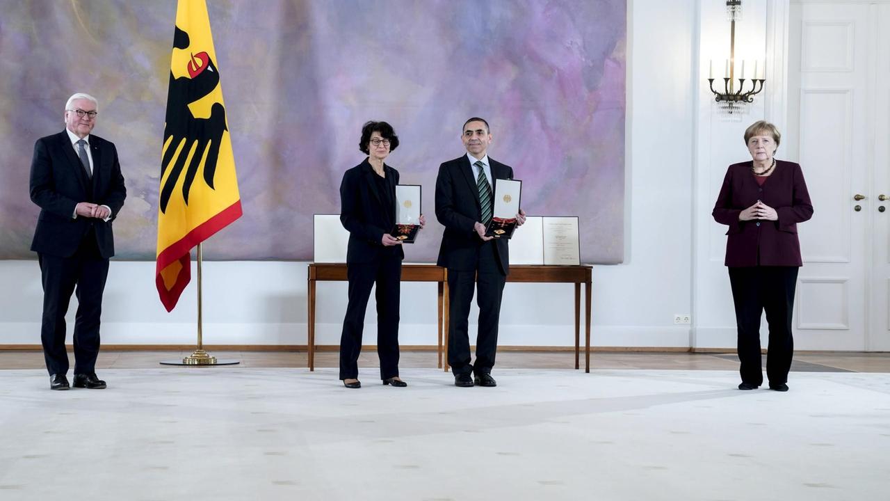 Verleihung des Bundesverdienstkreuz an die Biontech-Gruender, 19.03.2021: Bundespraesident Frank-Walter Steinmeier gemeinsam mit Bundeskanzlerin Dr. Angela Merkel und Forscherehepaar und Gründer des Unternehmens Biontech SE Özlem Türeci und Ugur Sahin bei der Verleihung des Großen Verdienstkreuzes mit Stern des Verdienstordens der Bundesrepublik Deutschland im Schloss Bellevue in Berlin Verleihung des Bundesverdienstkreuz an die Biontech-Gruender, 19.03.2021: Bundespraesident Frank-Walter Steinmeier gemeinsam mit Bundeskanzlerin Dr. Angela Merkel und Forscherehepaar und Gründer des Unternehmens Biontech SE Özlem Türeci und Ugur Sahin bei der Verleihung des Großen Verdienstkreuzes mit Stern des Verdienstordens der Bundesrepublik Deutschland im Schloss Bellevue in Berlin