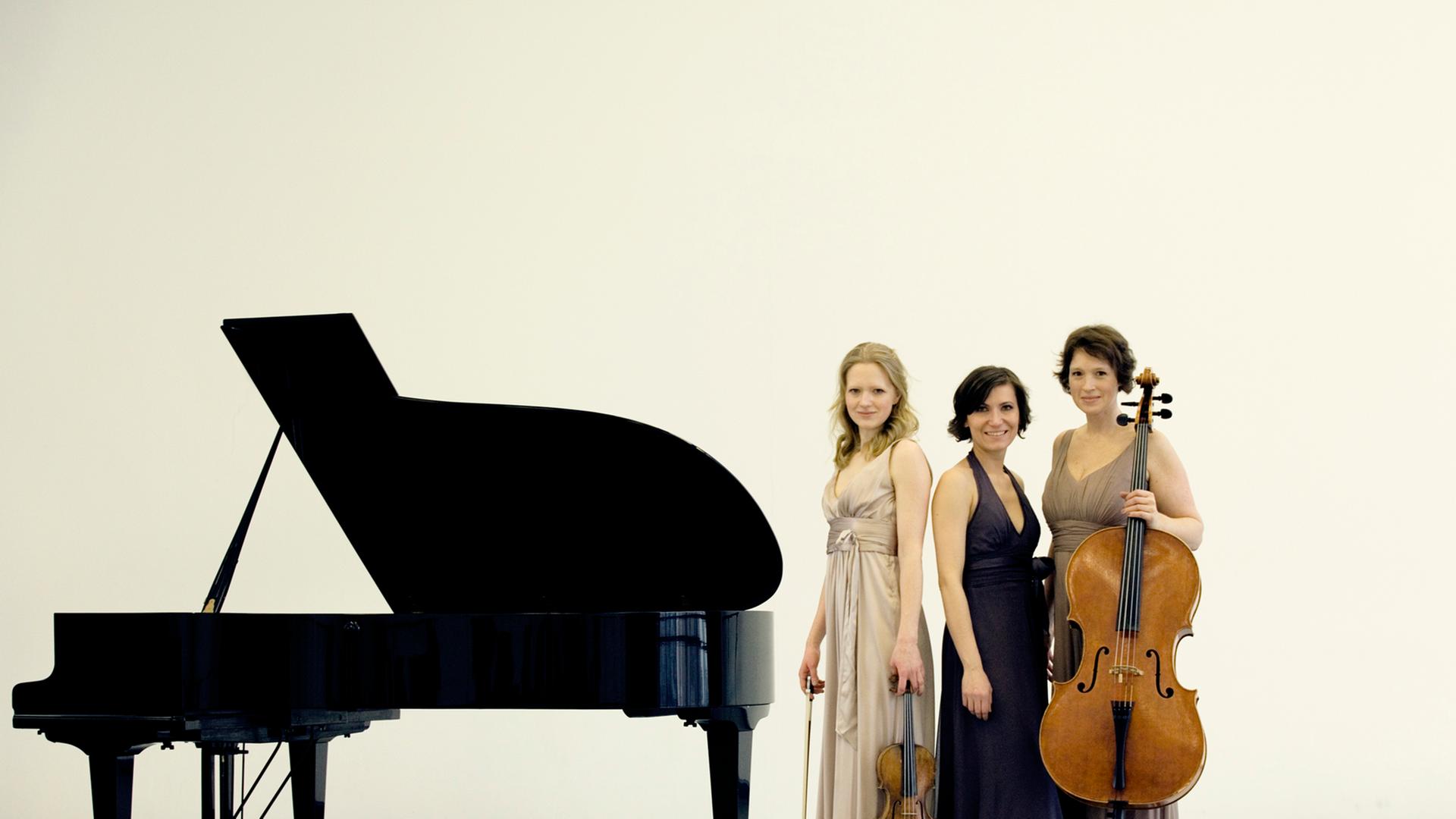 Das Boulanger Trio steht neben einem Klavier. Das Boulanger Trio steht neben einem Klavier.