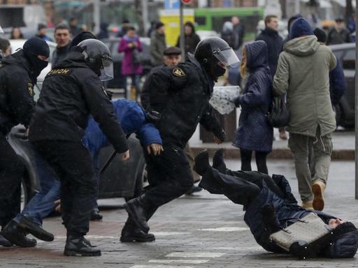 Polizisten stoßen am 25.03.2017 in Minsk (Weißrussland) auf einer Demonstration eine Teilnehmerin um.