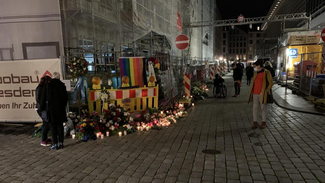 An der Straßenecke an der Schlossstraße, mitten in der Dresdener Innenstadt zwischen Kulturpalast und Residenzschloss, wo ein schwules Paar angegriffen und einer der beiden Männer getötet wurde, erinnern Blumenkränze und Kerzen an die Opfer. Inzwischen hat jemand dort auch eine Regenbogenfahne befestigt. An der Straßenecke an der Schlossstraße, mitten in der Dresdener Innenstadt zwischen Kulturpalast und Residenzschloss, wo ein schwules Paar angegriffen und einer der beiden Männer getötet wurde, erinnern Blumenkränze und Kerzen an die Opfer. Inzwischen hat jemand dort auch eine Regenbogenfahne befestigt.