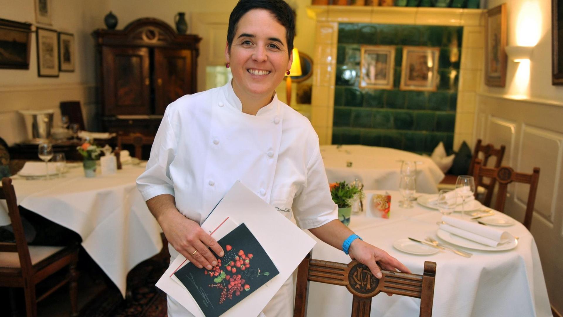 Douce Steiner im Restaurant an einen Stuhl gelehnt, mit der Karte in der Hand Douce Steiner im Restaurant an einen Stuhl gelehnt, mit der Karte in der Hand