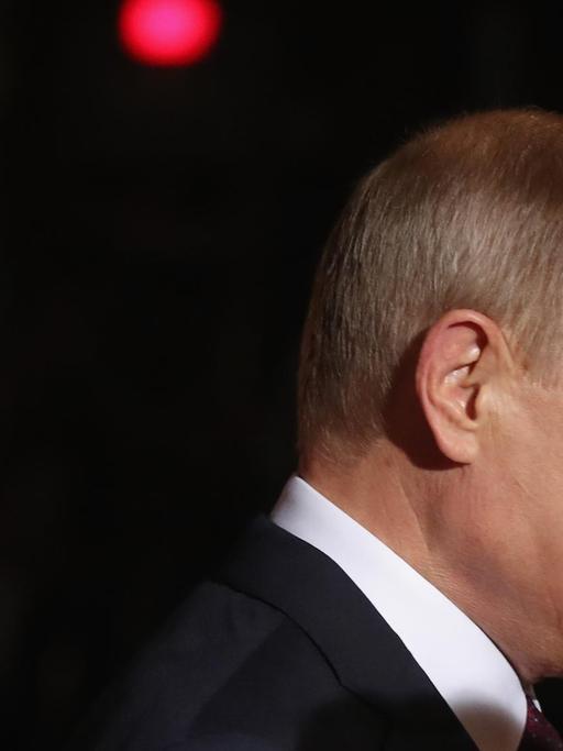 Seitenprofilbild von Vladimir Putin vor dunklem Hintergrund.