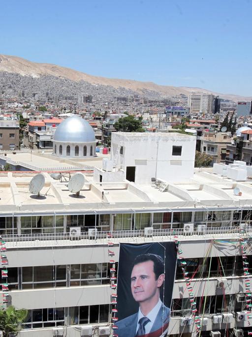 Porträts des syrischen Präsidenten Baschar al-Assad an einem Gebäude in Damaskus