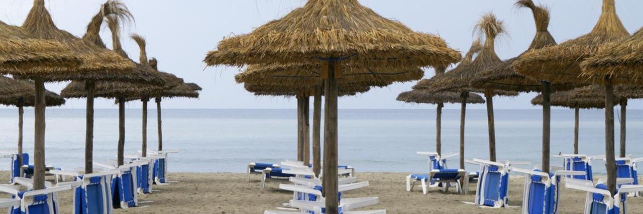 Sonnenschirme und Tische am Strand, Mallorca, Spanien Sonnenschirme und Tische am Strand, Mallorca, Spanien