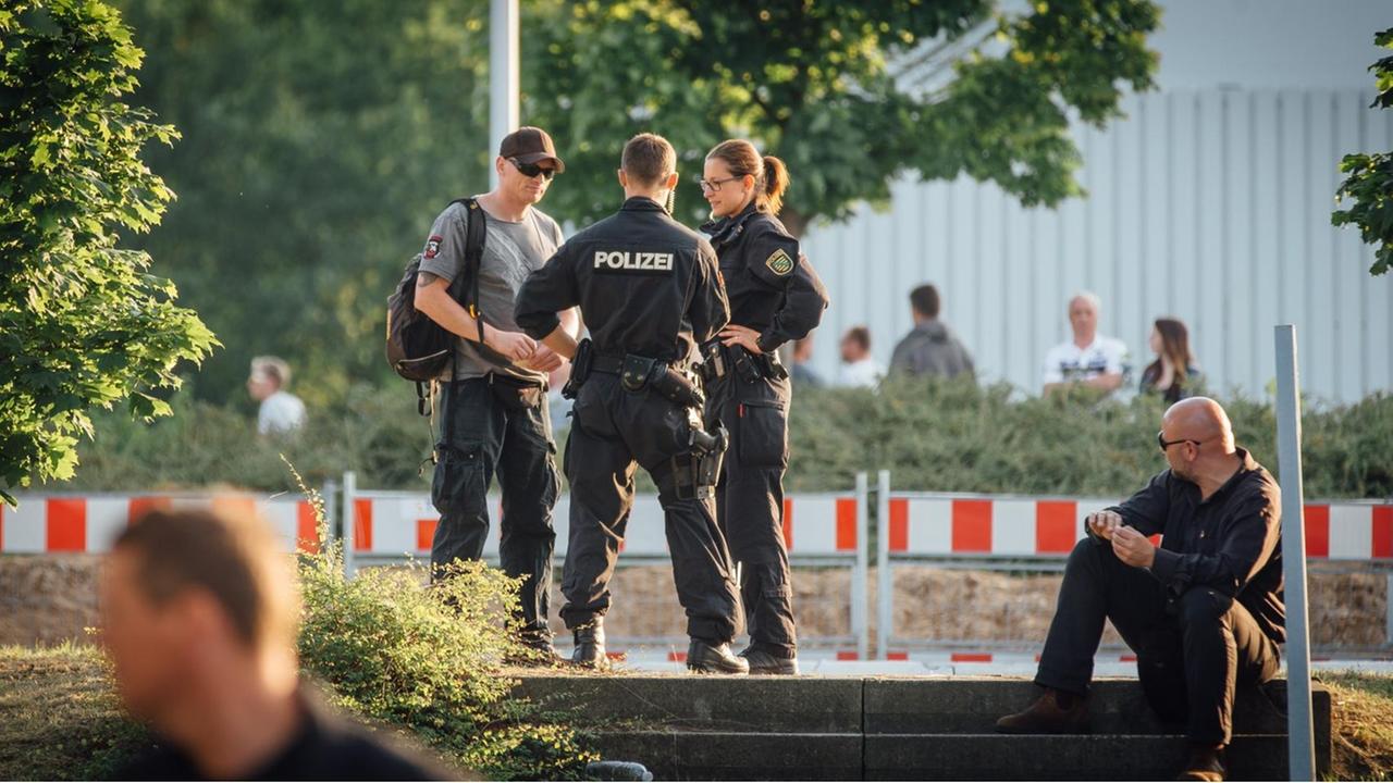 Polizisten bei einer Kontrollen auf dem Parkplatz vor dem ehemaligen Baumarkt in Heidenau.