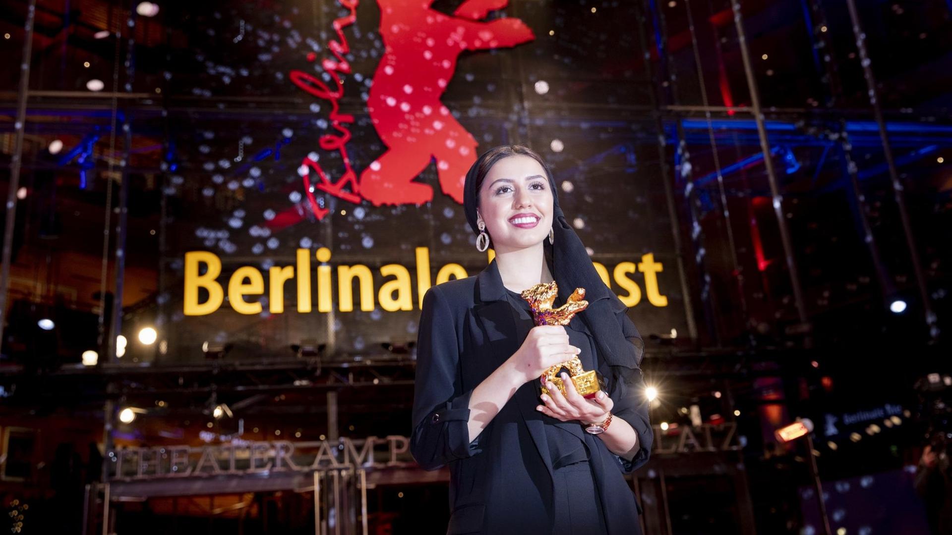 29.02.2020, Berlin: 70. Berlinale, Preisverleihung: Baran Rasoulof steht mit dem Goldenen Bären für ihren Vater, den Regisseur Mohammad Rassulof, für den Besten Film vor dem Berlinale Palast. 29.02.2020, Berlin: 70. Berlinale, Preisverleihung: Baran Rasoulof steht mit dem Goldenen Bären für ihren Vater, den Regisseur Mohammad Rassulof, für den Besten Film vor dem Berlinale Palast.
