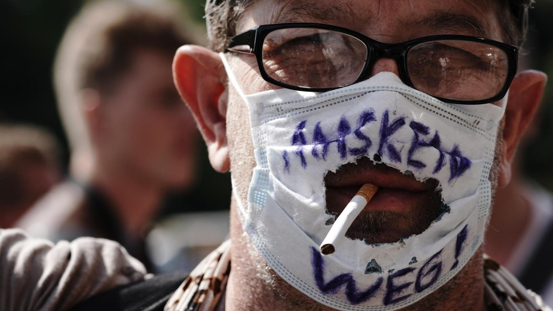 "Masken Weg!" steht auf dem "Mundschutz" eines Teilnehmers einer Demonstration gegen die Corona-Maßnahmen. "Masken Weg!" steht auf dem "Mundschutz" eines Teilnehmers einer Demonstration gegen die Corona-Maßnahmen.