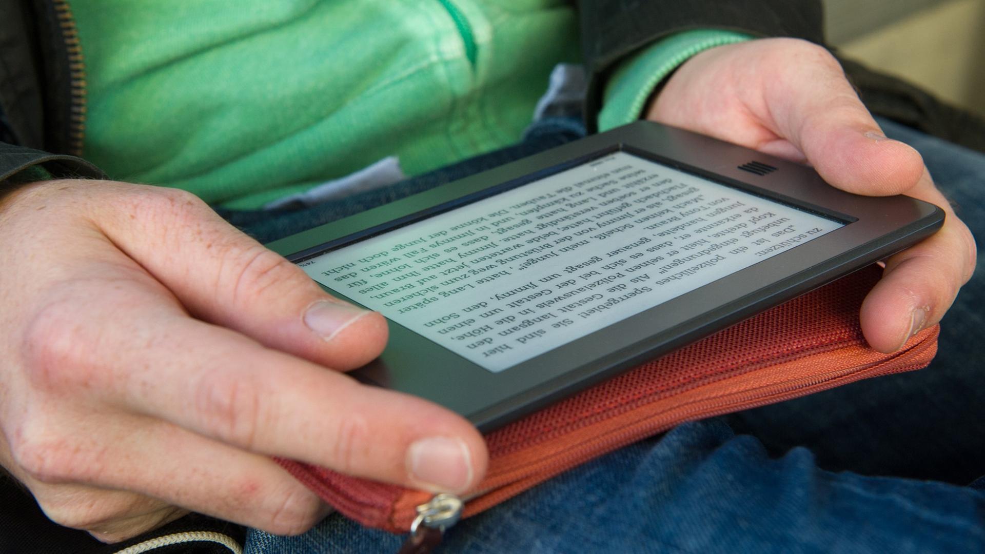 Ein Mann hält am 28.09.2012 in München (Bayern) ein elektronischen Reader der Marke Kindle in seinen Händen. Ein Mann hält am 28.09.2012 in München (Bayern) ein elektronischen Reader der Marke Kindle in seinen Händen.