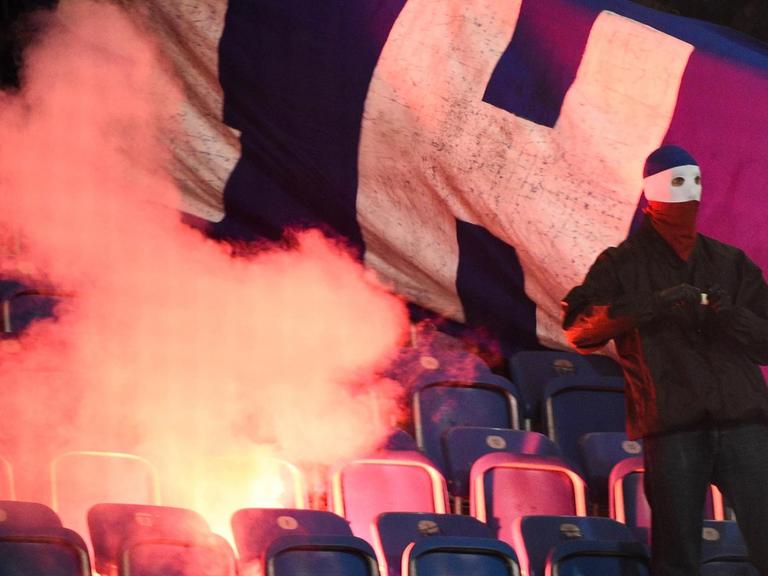 Rostocker Hooligans zünden Stadionsitze und einen Banner der Berliner an.