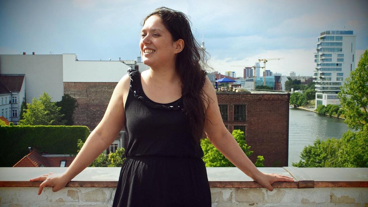 Jacinta Nandi lehnt sich an ein Terrassengeländer. Im Hintergrund ist die Spree und das Hochhaus " Living Levels " zu sehen. Jacinta Nandi lehnt sich an ein Terrassengeländer. Im Hintergrund ist die Spree und das Hochhaus " Living Levels " zu sehen.