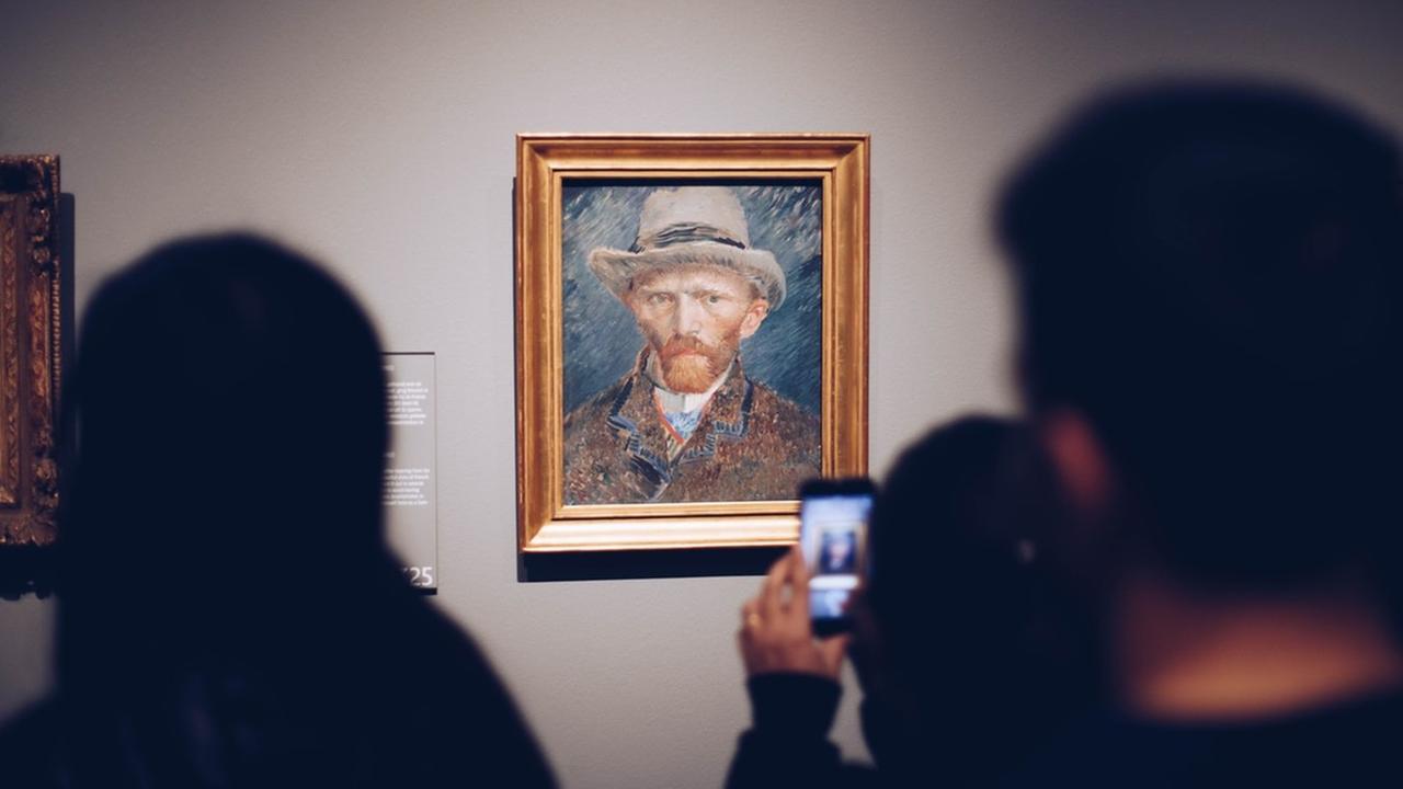 Ein Mann im Rijksmuseum in Amsterdam macht mit seinem Handy ein Foto von van Goghs Selbstporträt. Ein Mann im Rijksmuseum in Amsterdam macht mit seinem Handy ein Foto von van Goghs Selbstporträt.