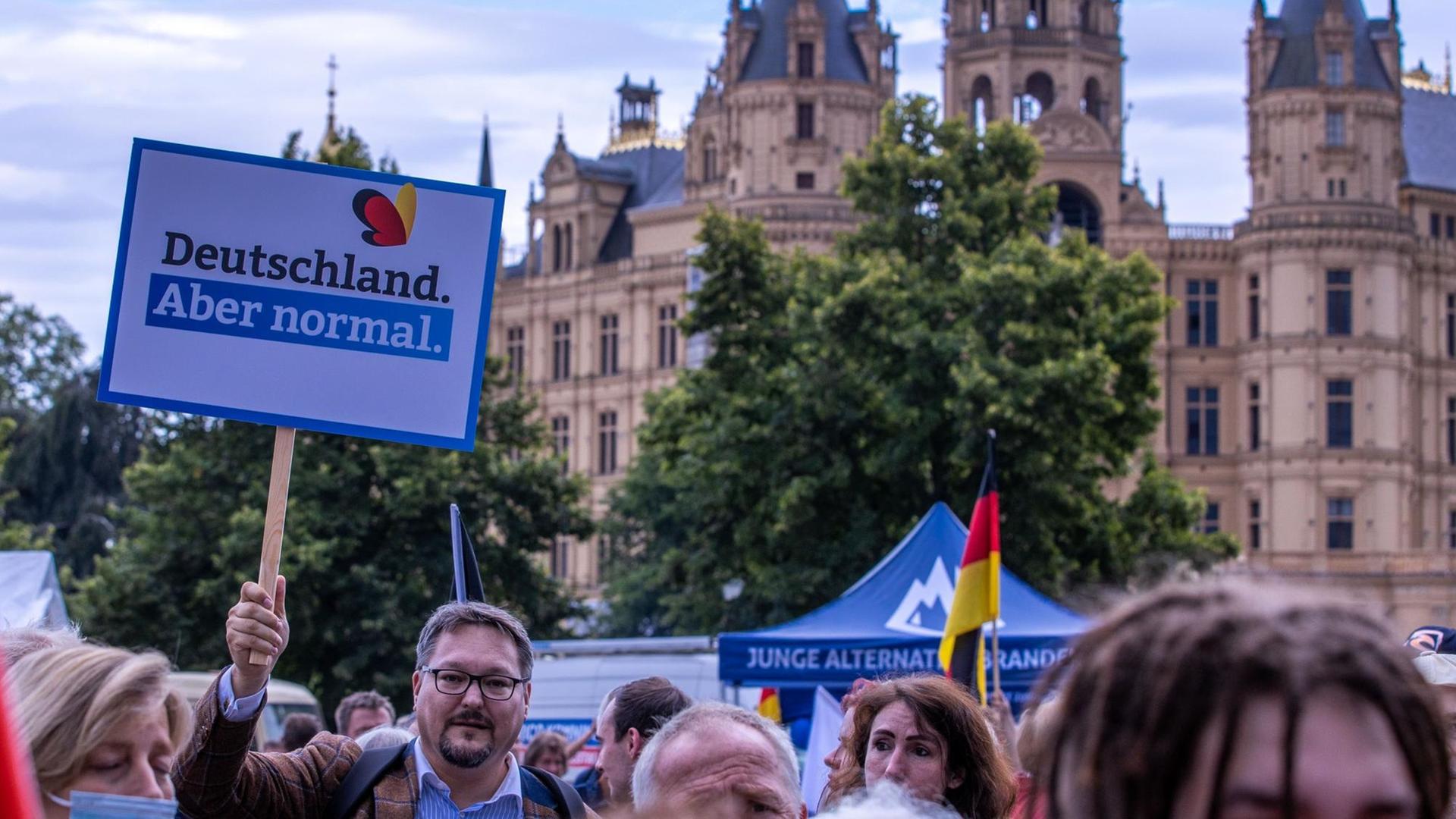 Anhänger der AfD stehen zum Auftakt der Wahlkampftour der AfD vor dem Schweriner Schloss. In jüngsten Wählerbefragungen kam die AfD auf zehn bis elf Prozent. Die Partei zieht mit dem Slogan «Deutschland. Aber normal.» in den Wahlkampf. Anhänger der AfD stehen zum Auftakt der Wahlkampftour der AfD vor dem Schweriner Schloss. In jüngsten Wählerbefragungen kam die AfD auf zehn bis elf Prozent. Die Partei zieht mit dem Slogan «Deutschland. Aber normal.» in den Wahlkampf.