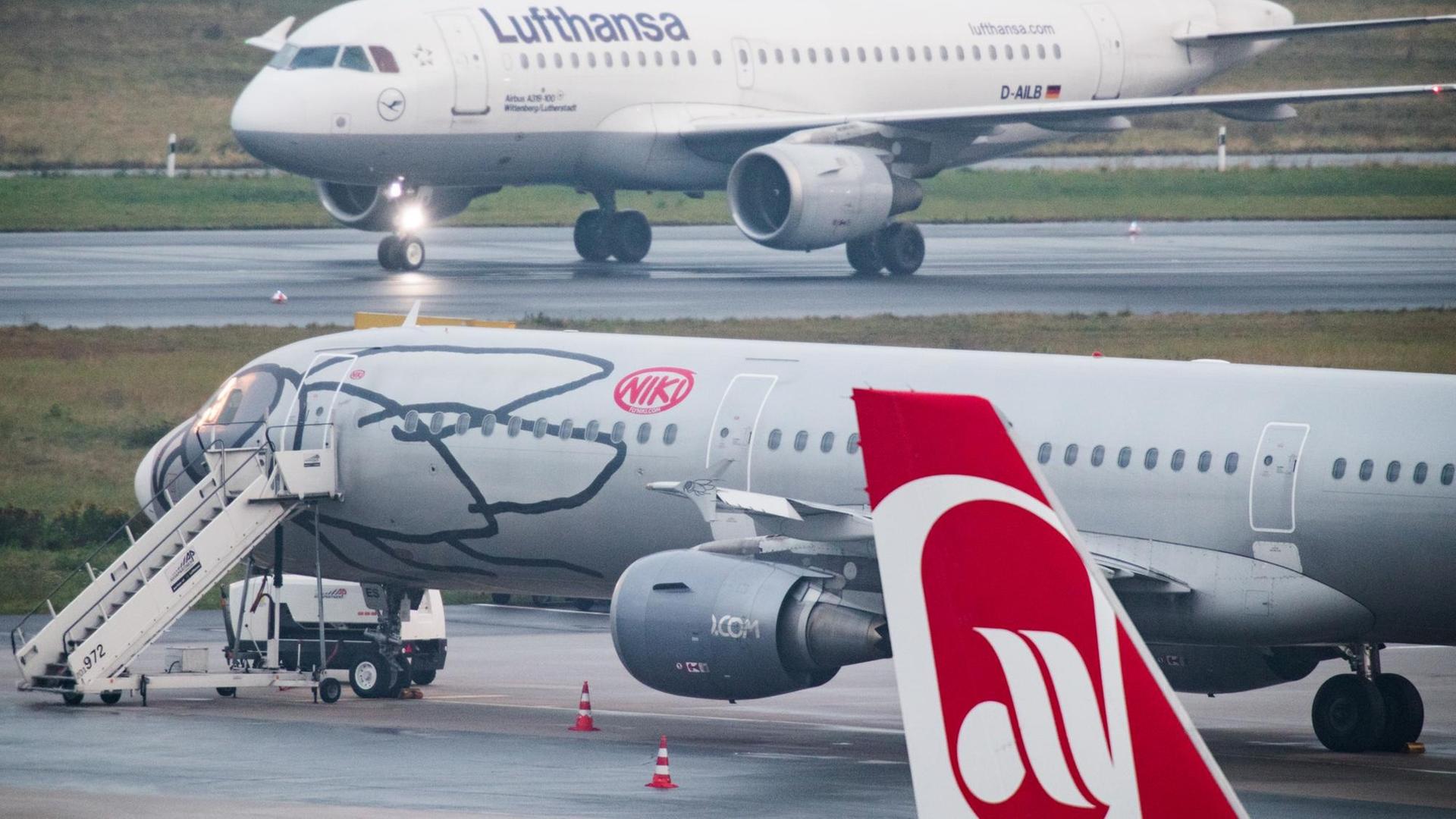 Ein Flugzeug der Lufthansa rollt am Flughafen Düsseldorf an Flugzeugen der Fluggesellschaften Niki und Air Berlin vorbei.
