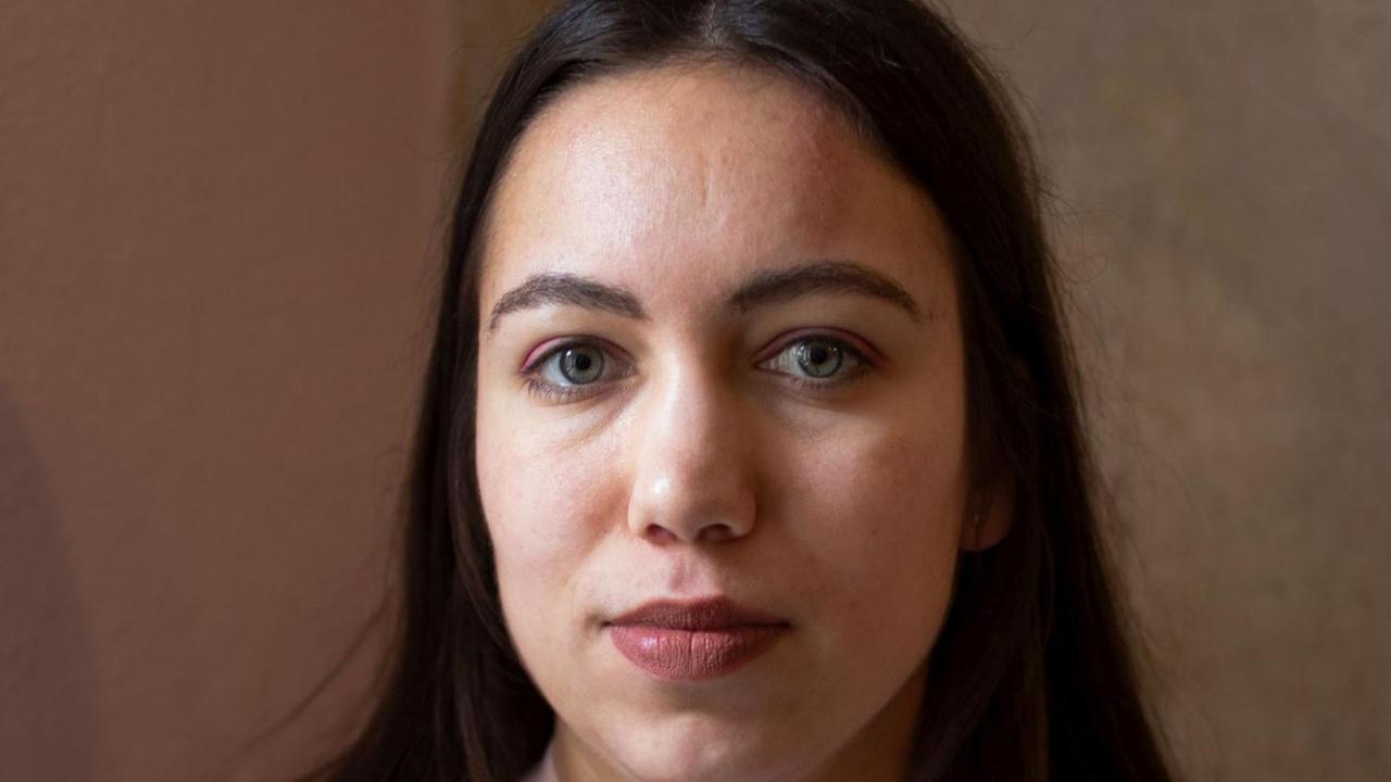 Ronya Othmann schaut in die Kamera. Sie hat lange, dunkla Haare und trägt ein rosafarbenes Adidas-Shirt. Ronya Othmann schaut in die Kamera. Sie hat lange, dunkla Haare und trägt ein rosafarbenes Adidas-Shirt.