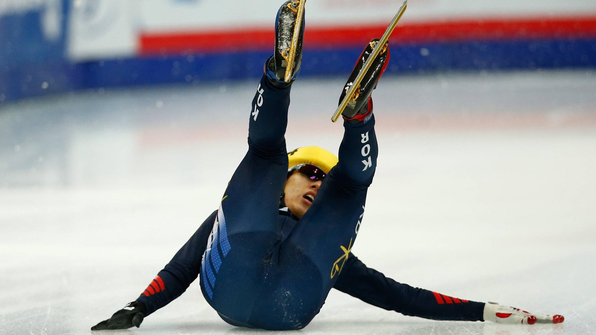 Ein Eisläufer (Short Track) stürzt Ein Eisläufer (Short Track) stürzt