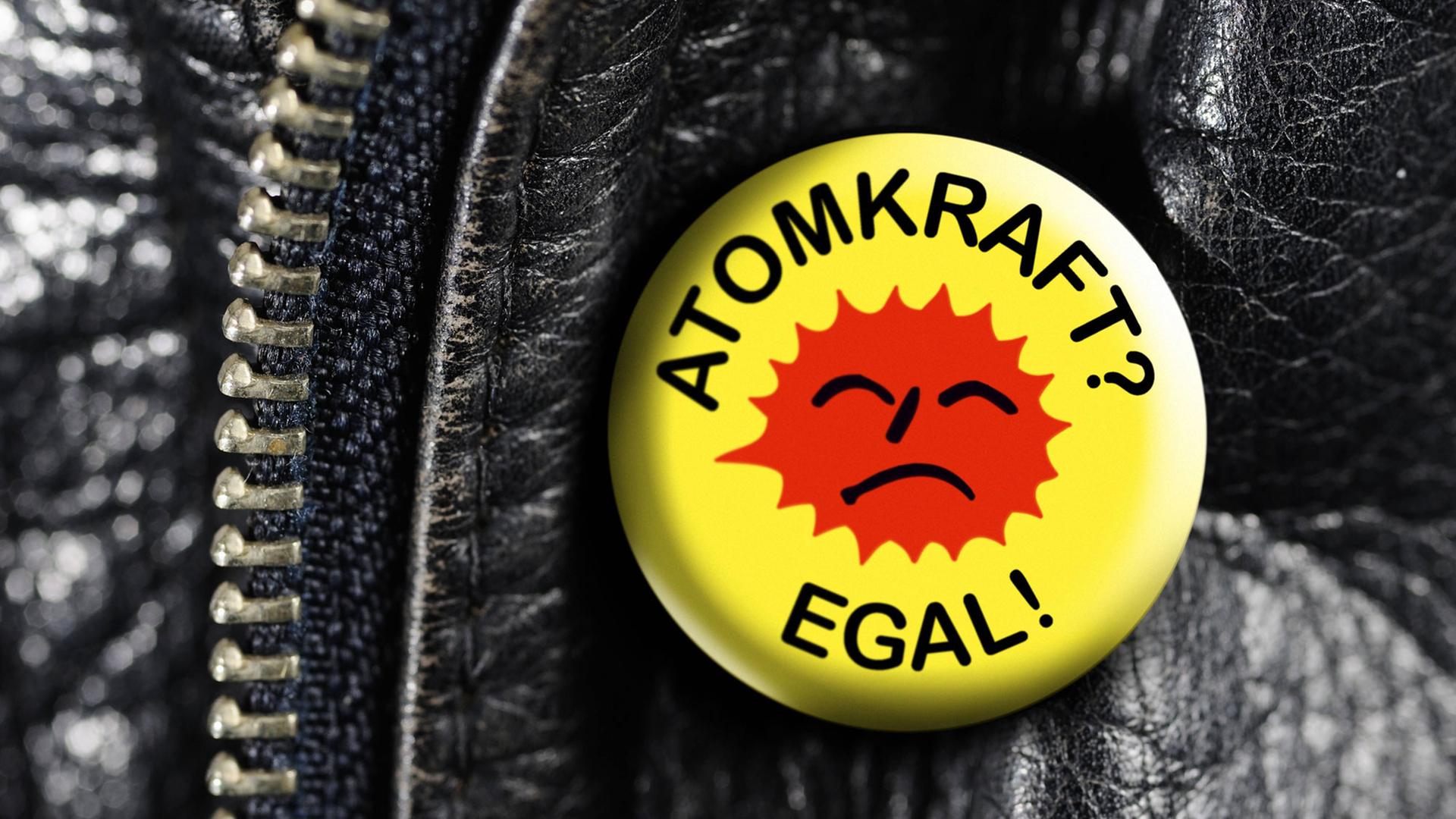 Nahaufnahme einer Lederjacke mit einem gelben Anstecker mit der Aufschrift: "Atomkraft? Egal!"
