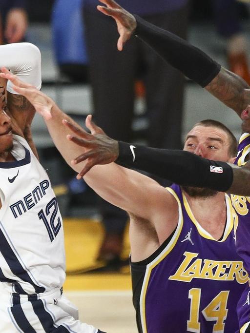 Ja Morant von den Memphis Grizzlies versucht den Ball an Marc Gasol und Dennis Schröder von den Los Angeles Lakers vorbeizubringen.