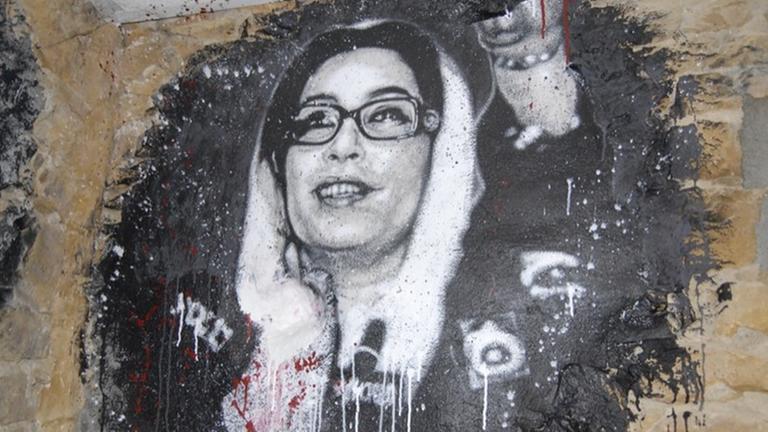 Graffiti von Benazir Bhutto, teilweise mit roter Farbe beschmiert