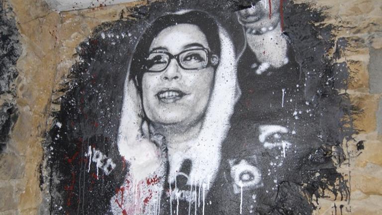 Graffiti von Benazir Bhutto, teilweise mit roter Farbe beschmiert Graffiti von Benazir Bhutto, teilweise mit roter Farbe beschmiert