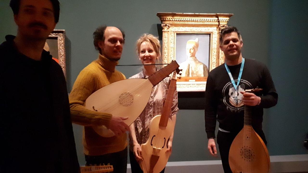 Vier Musiker des Ensembles stehen vor einem Bild der Ausstellung. Vier Musiker des Ensembles stehen vor einem Bild der Ausstellung.