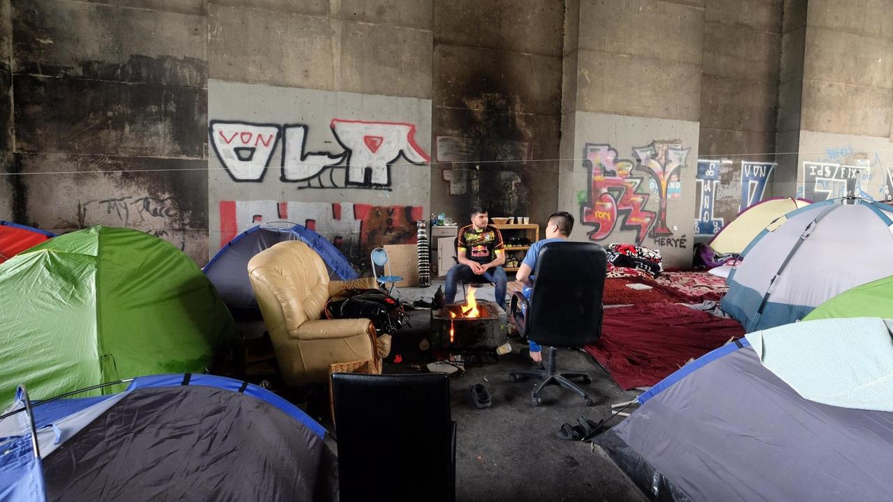 Flüchtlinge in einem Camp unter der Brücke in Porte de la Chapelle in Paris, aufgenommen im April 2018. Flüchtlinge in einem Camp unter der Brücke in Porte de la Chapelle in Paris, aufgenommen im April 2018.
