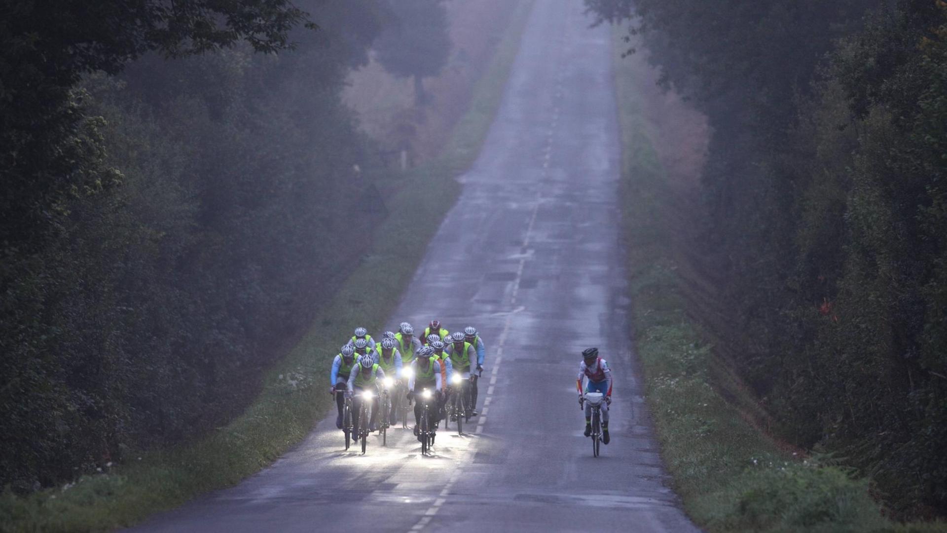 Ein Radteam fährt bei dem 1200km Rennen Paris-Brest-Paris durch den morgendlichen Nebel. Ein Radteam fährt bei dem 1200km Rennen Paris-Brest-Paris durch den morgendlichen Nebel.