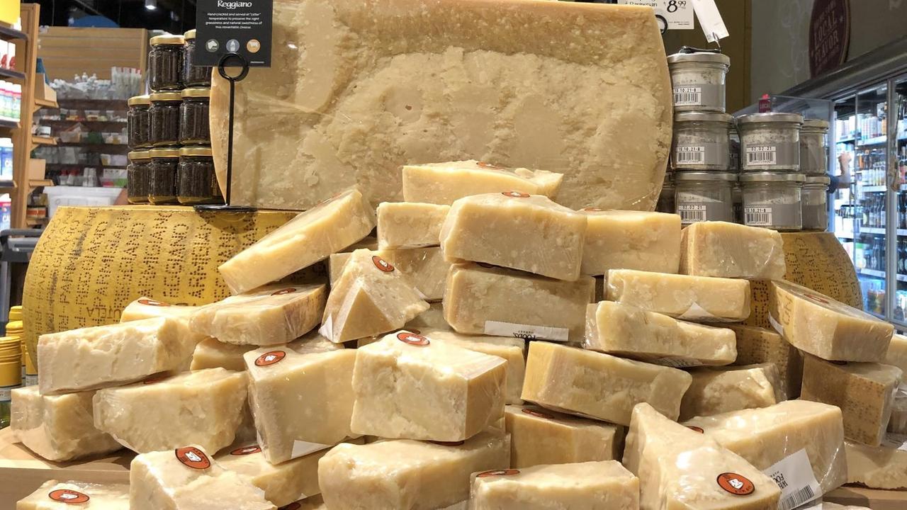 Große Parmesanstücke sind in einem Supermarkt aufgetürmt Große Parmesanstücke sind in einem Supermarkt aufgetürmt