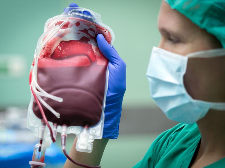 Eine Ärztin hält einen Beutel mit Erythrozyten-Konzentrat - im Volksmund "Blutkonserve" genannt - in einem Operationssaal des Universitätsklinikums Münster.