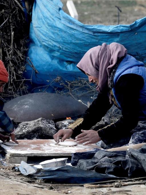 Eine Mutter mit ihrem Kind beim Backen in einem Flüchtlingscamp in Torbali, Izmir, in der Türkei