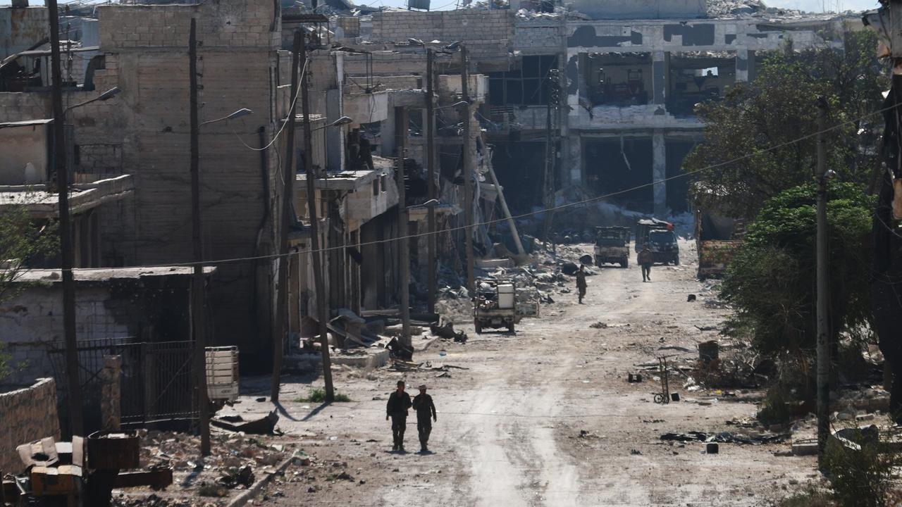 Zwei syrische Kämpfer laufen durch das durch Bomben zerstörte Stadtviertel Ramussa am Rande der syrischen Stadt Aleppo