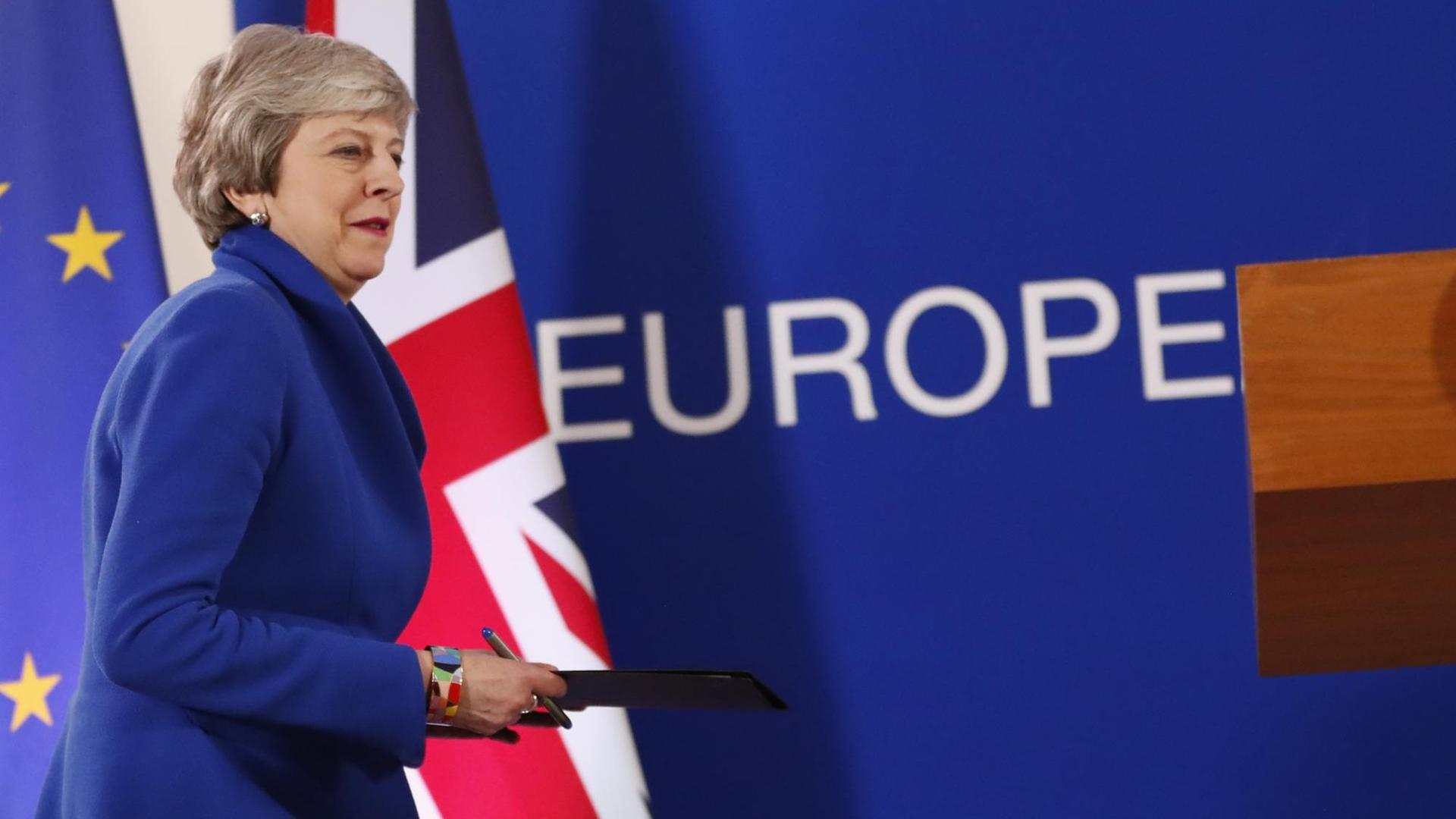 Die britische Premierministerin Theresa May geht auf ein Rednerpult zu. Die britische Premierministerin Theresa May geht auf ein Rednerpult zu.