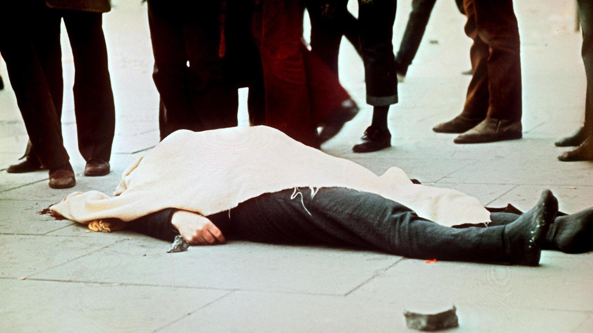 Mit einem Tuch bedeckt liegt eines der Todesopfer auf dem Boden. Am 30. Januar 1972 wurden 13 katholische Demonstranten während einer friedlichen, jedoch verbotenen Kundgebung in der nordirischen Stadt Derry von britischen Fallschirmjägern erschossen. Mit einem Tuch bedeckt liegt eines der Todesopfer auf dem Boden. Am 30. Januar 1972 wurden 13 katholische Demonstranten während einer friedlichen, jedoch verbotenen Kundgebung in der nordirischen Stadt Derry von britischen Fallschirmjägern erschossen.