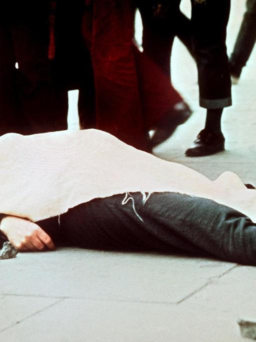 Mit einem Tuch bedeckt liegt eines der Todesopfer auf dem Boden. Am 30. Januar 1972 wurden 13 katholische Demonstranten während einer friedlichen, jedoch verbotenen Kundgebung in der nordirischen Stadt Derry von britischen Fallschirmjägern erschossen.