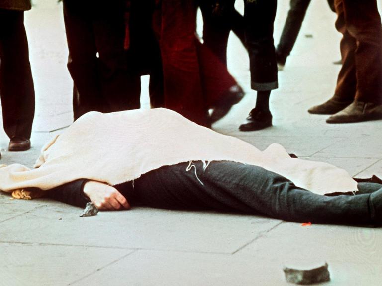 Mit einem Tuch bedeckt liegt eines der Todesopfer auf dem Boden. Am 30. Januar 1972 wurden 13 katholische Demonstranten während einer friedlichen, jedoch verbotenen Kundgebung in der nordirischen Stadt Derry von britischen Fallschirmjägern erschossen.