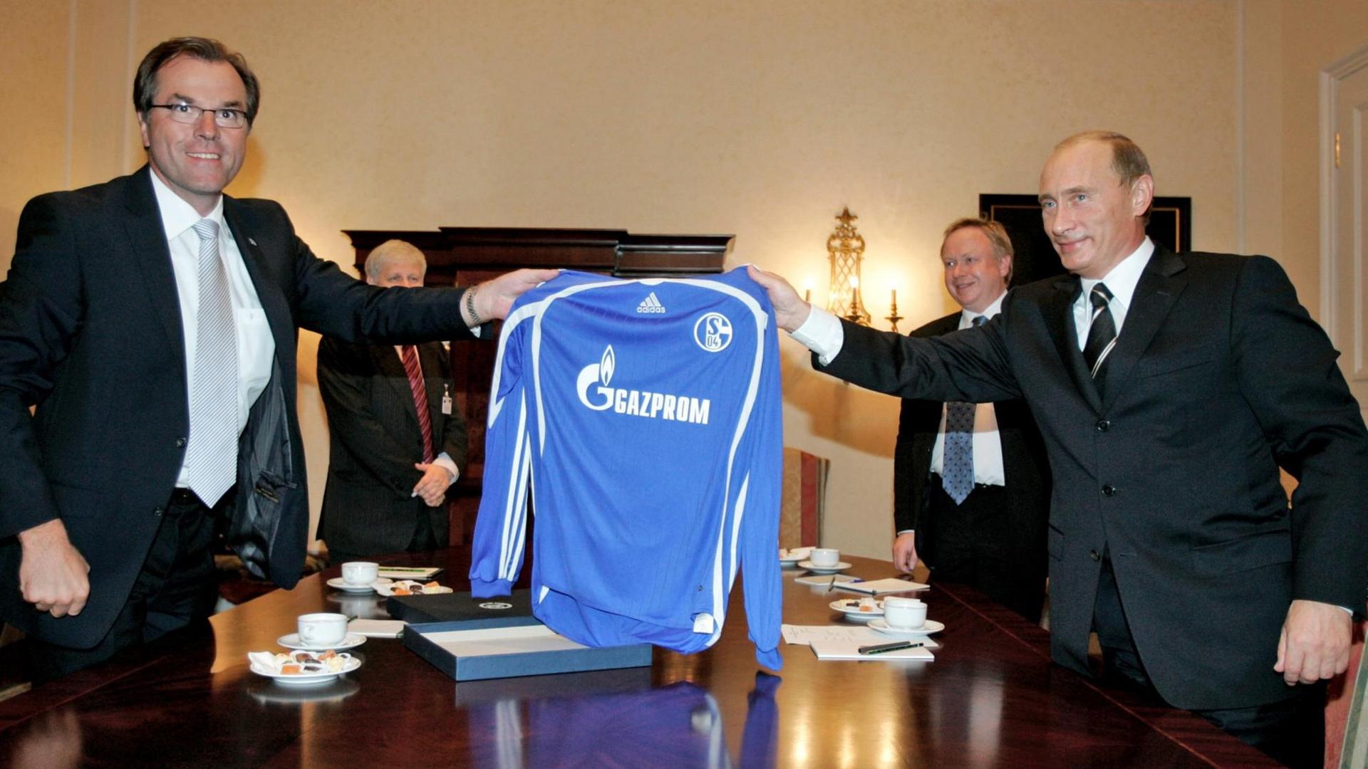 Der russische Präsident Wladimir Putin (r) und Clemens Tönnies, Aussichtsratsvorsitzender des Bundesligavereins Schalke 04, halten ein Schalke-Trikot mit der Aufschrift des Sponsors Gazprom. Der russische Präsident Wladimir Putin (r) und Clemens Tönnies, Aussichtsratsvorsitzender des Bundesligavereins Schalke 04, halten ein Schalke-Trikot mit der Aufschrift des Sponsors Gazprom.