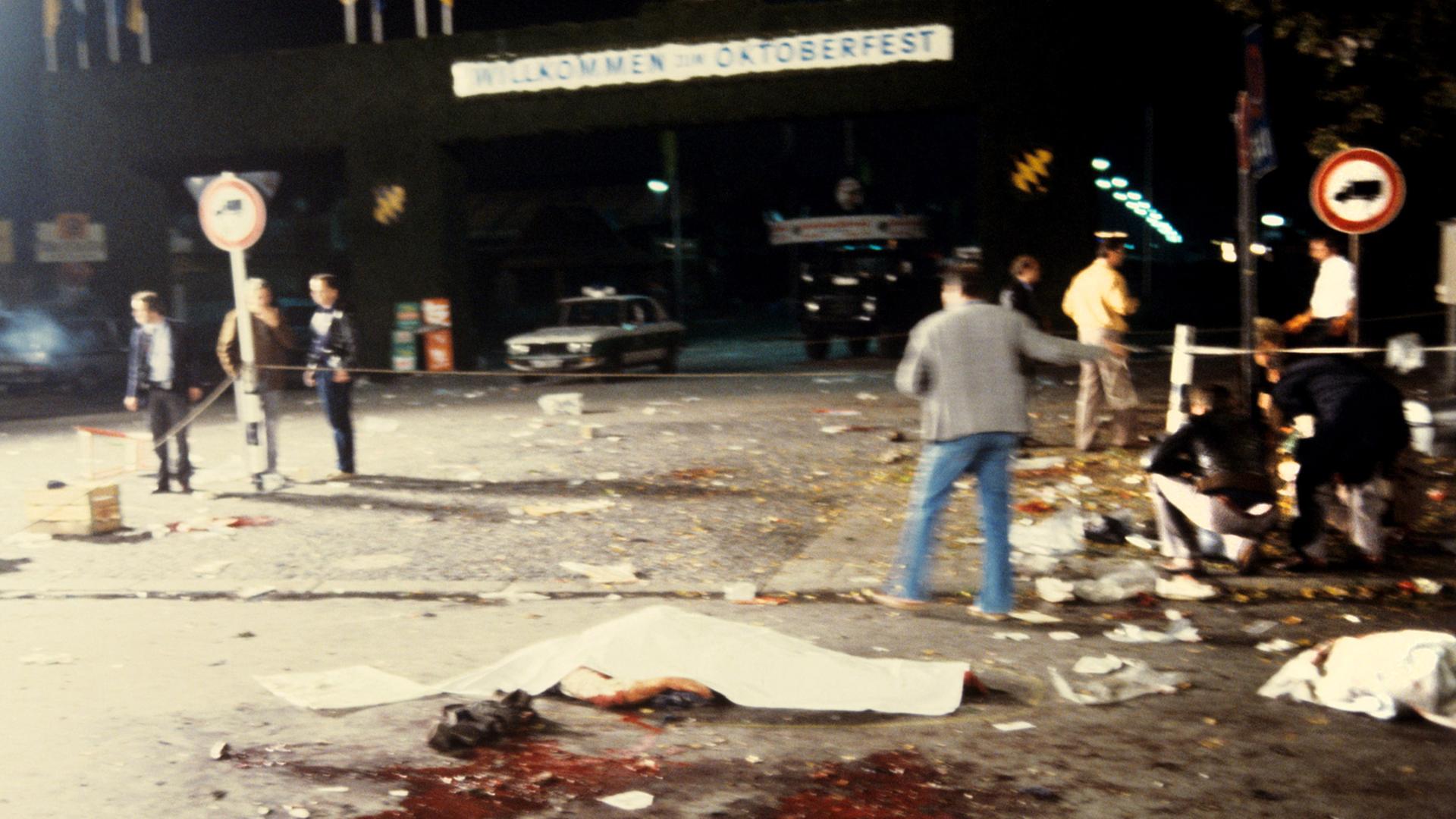 Mit Tüchern zugedeckte Todesopfer liegen neben Blutlachen am Tatort des nächtlichen Anschlages auf dem Münchner Oktoberfest am 26.9.1980.