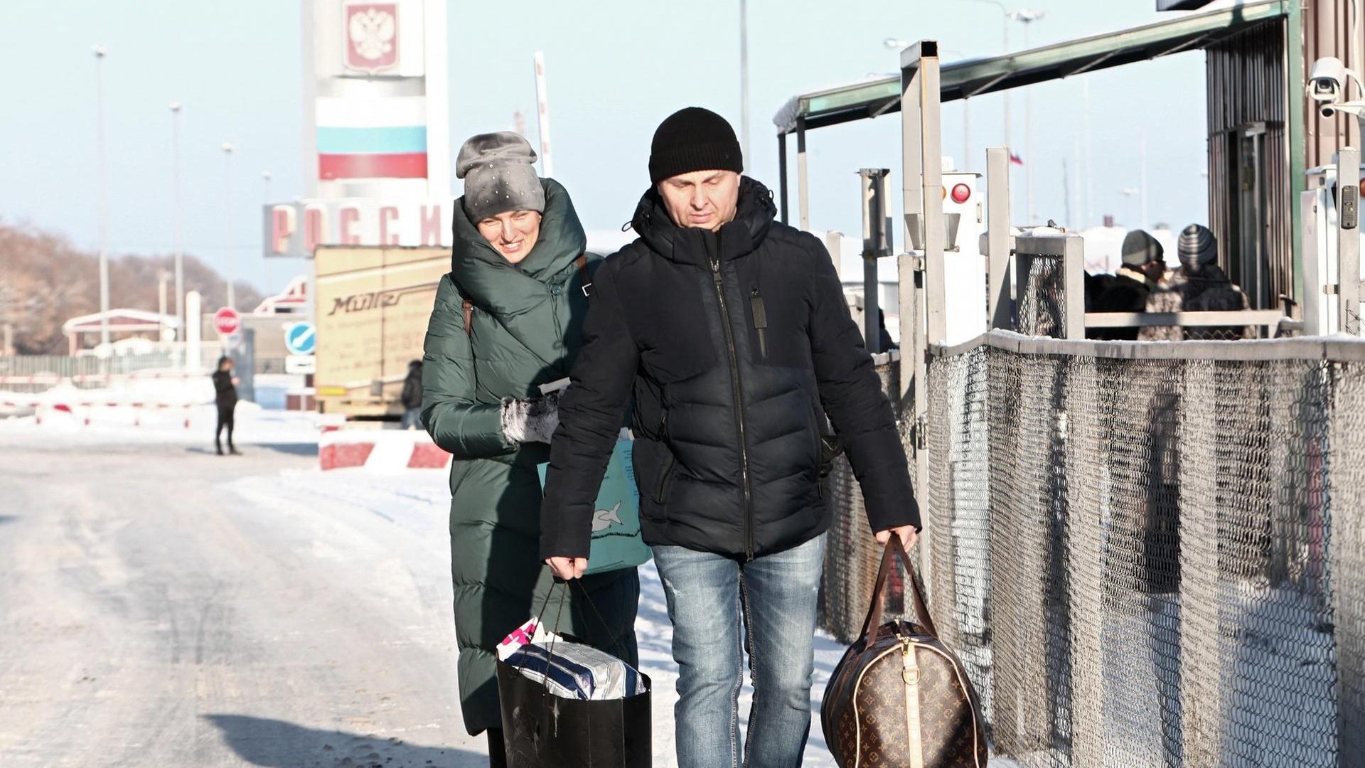 Eine Frau und ein Mann passieren den Hoptivka-Grenzübergang im Nordosten der Ukraine Eine Frau und ein Mann passieren den Hoptivka-Grenzübergang im Nordosten der Ukraine