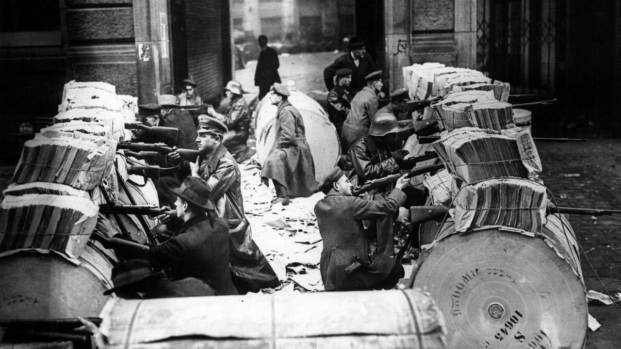 Die revolutionären Spartakisten mit Gewehren im Anschlag hinter Barrikaden aus Fässern in den Straßen von Berlin, aufgenommen am 11. Januar 1919. Die revolutionären Spartakisten mit Gewehren im Anschlag hinter Barrikaden aus Fässern in den Straßen von Berlin, aufgenommen am 11. Januar 1919.