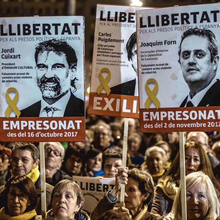Demonstranten zeigen Plakate mit Abbildungen inhaftierter katalanischer Separatistenführer bei einem Protest gegen den gerichtlichen Prozess, der gegen sie geführt wird. 