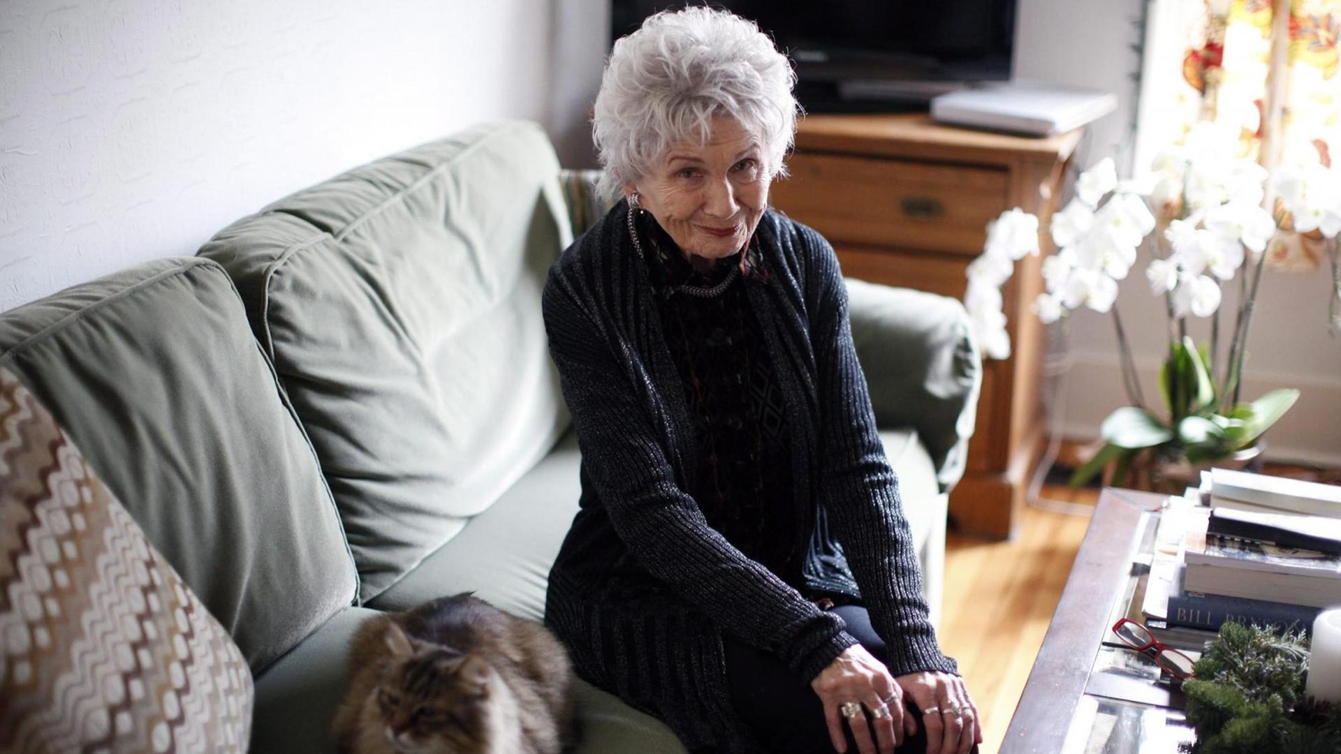 Die kanadische Schriftstellerin Alice Munro sitzt bei ihrer Tochter zu Hause auf dem Sofa, neben sich eine Katze.
