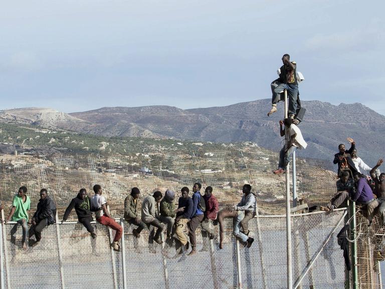 Afrikanische Flüchtlinge versuchen, den Grenzzaun zur spanischen Exklave Melilla zu überwinden.