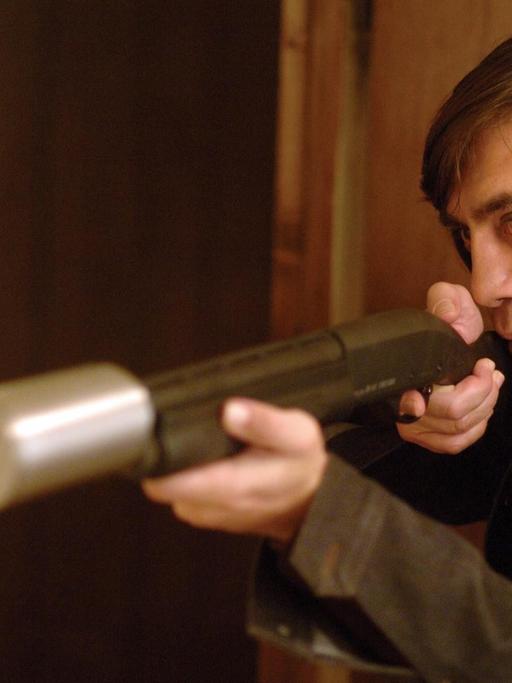 Javier Bardem mit einem Bolzenschussgerät im Anschlag in einer Filmszene aus "No Country for Old Men".
