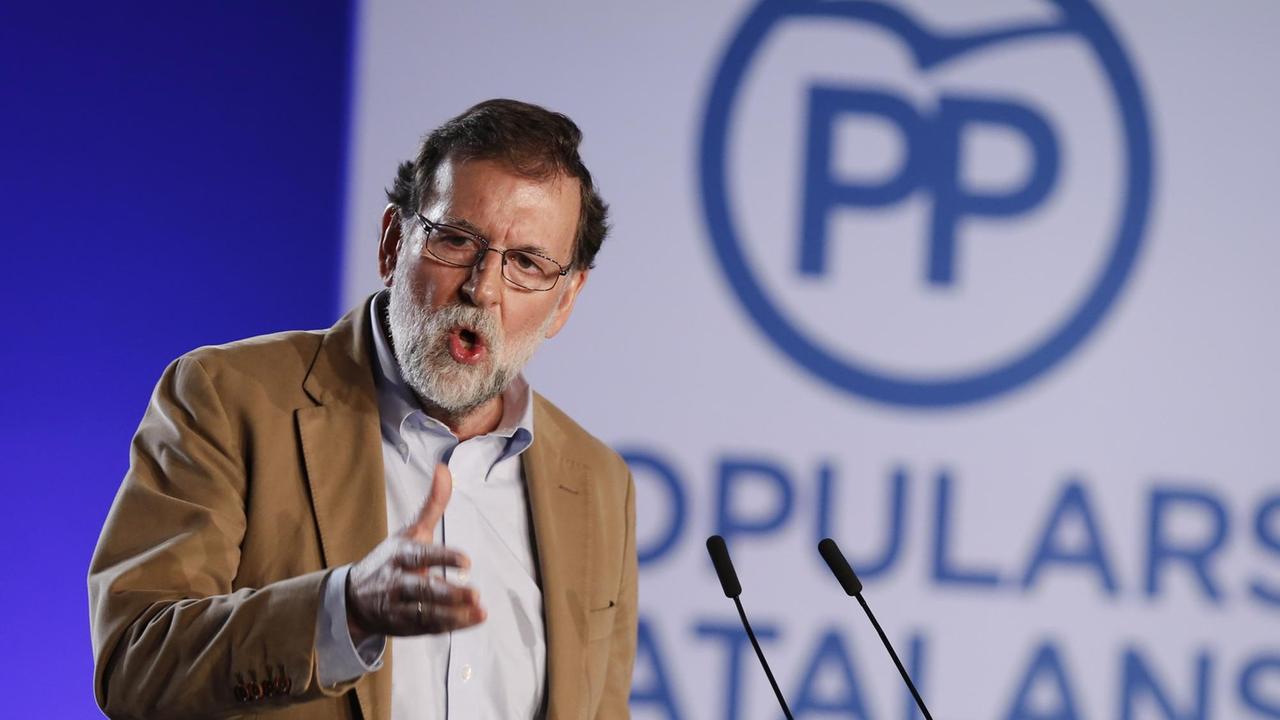 Spaniens Ministerpräsident Mariano Rajoy am Rednerpult in Barcelona. Hinter ihm das Logo seiner Partei "Partido Popular"